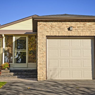 A brown brick starter home with one-car garage