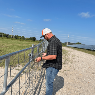 image of Operations manager Bart Hautala closes the gate at the Heritage Sustainable Energy solar array in Traverse City, Michigan.
