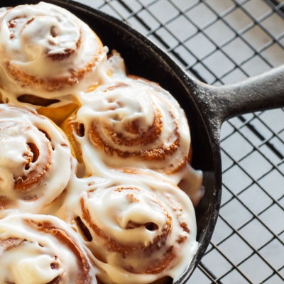 Iced cinnamon rolls in a cast iron skillet