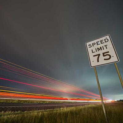 speed limit sign with motion blur of car headlights 