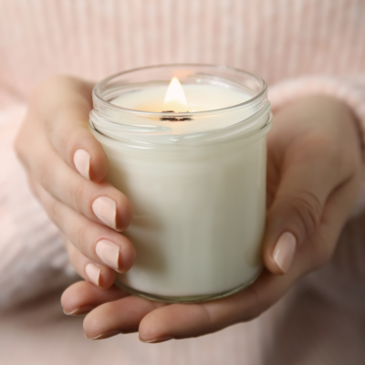 A woman's hands holding a small white candle