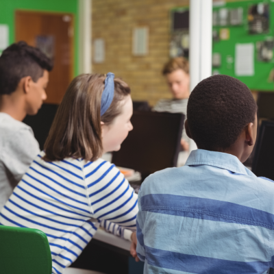 A group of students viewed from behind in a classroom setting.