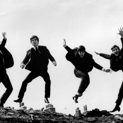Photo of the Beatles, April 1963; L-R: Ringo Starr, George Harrison, Paul McCartney, John Lennon - are jumping on top of a brick wall