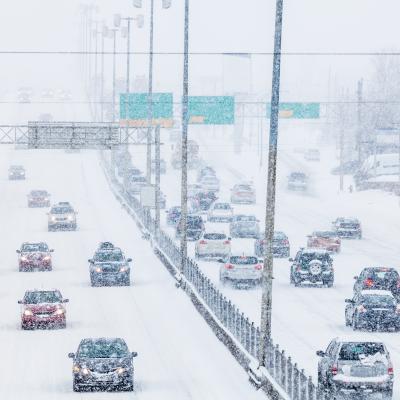 view of cars driving on freeway in both directions in blizzard conditions