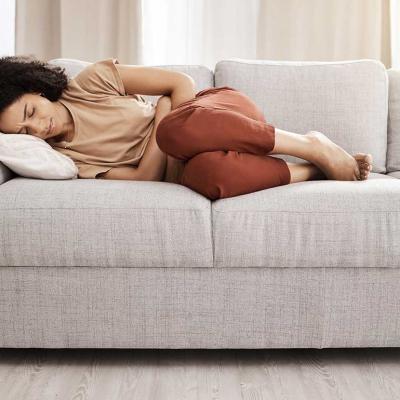 woman curled up on couch from pain