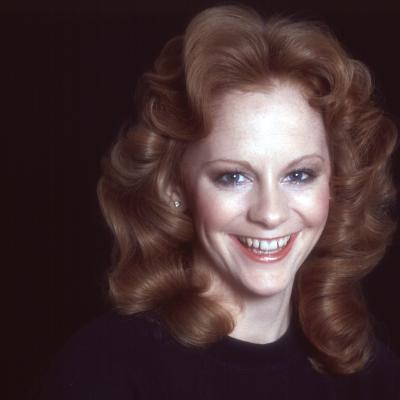 Portrait of Reba McEntire on a black background in 1960.