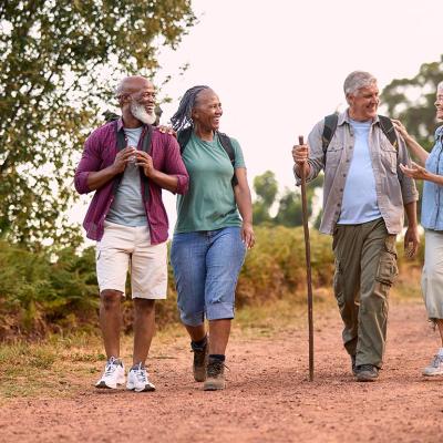 group of four seniors walking in the countryside