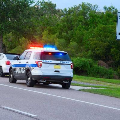 highway patrol pulling over driver next to speed limit sign