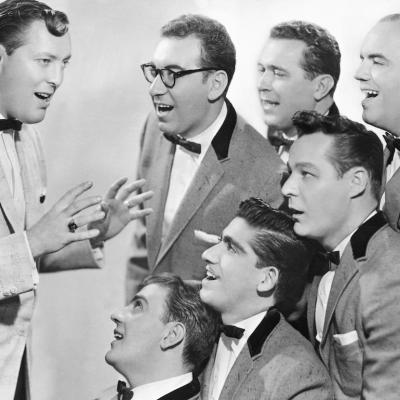 Bill Haley & His Comets sing in matching tuxedos.