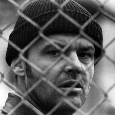 Actor Jack Nicholson looking through fence in a scene from the 1975 film 'One Flew Over The Cuckoo's Nest.'