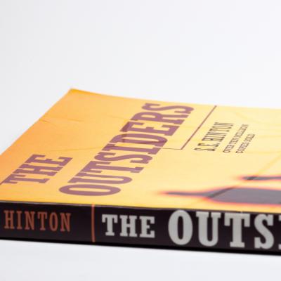 Close-up image of 'The Outsiders' book by S.E. Hinton.