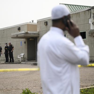 Police and community members gather outside the burned-out Tawhid Islamic Center on May 17, 2023 in St. Paul, Minnesota.