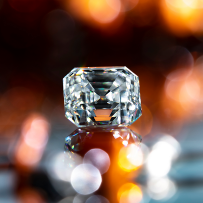 A diamond is displayed against a backdrop of orange and gold lighting.