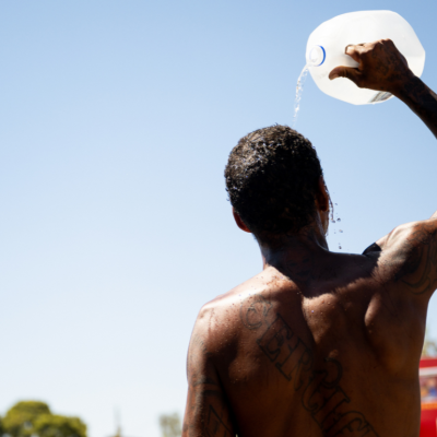 A person cools off by pouring a gallon jug of water over their head amid searing heat that was forecast to reach 115 degrees Fahrenheit on July 16, 2023 in Phoenix, Arizona. 