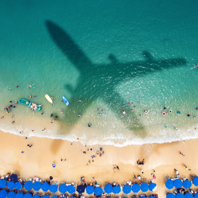 shadow of plane over tropical beach