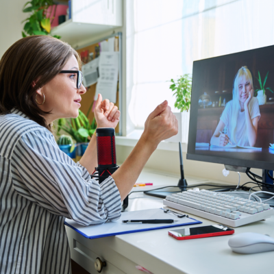 Woman sitting in front of a computer for a virtual meeting with a therapist.
