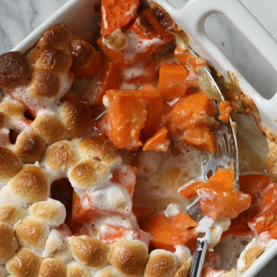 Sweet potato casserole topped with roasted marshmallows in a white baking tray