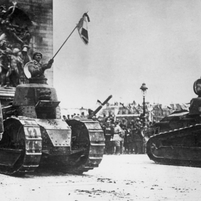 French soldiers holding flags and riding in tanks in front of the Arc de Triomphe on the Champs Elysees during a Bastille Day Victory Parade celebrating the end of World War I, Paris, France. 
