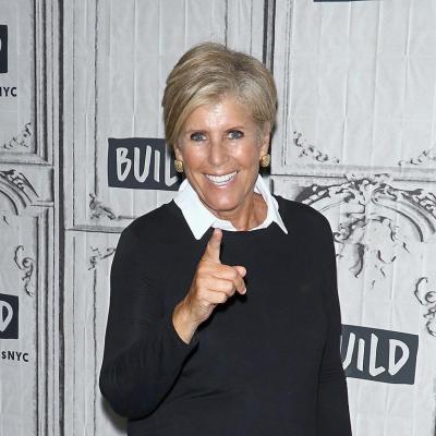 Suze Orman points at camera wearing white shirt under black sweater at an event on September 17, 2018 in New York City.