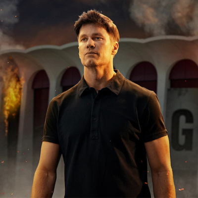 Tom Brady with a burning stadium in the background in a promotional still for 'The Roast of Tom Brady'