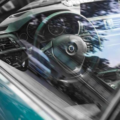 View of steering wheel and dashboard through driver's side window of new vehicle.