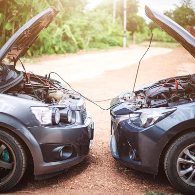 Two cars on a roadside showing a jump-start.