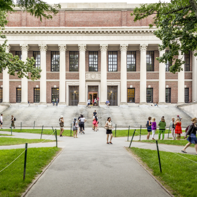 View of the campus of the famous Harvard University in Cambridge, Massachusetts, USA with some students, locals, and tourists passing by.