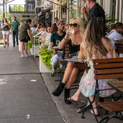 Diners during the day in a lane in New York City enjoying some alfresco dining.