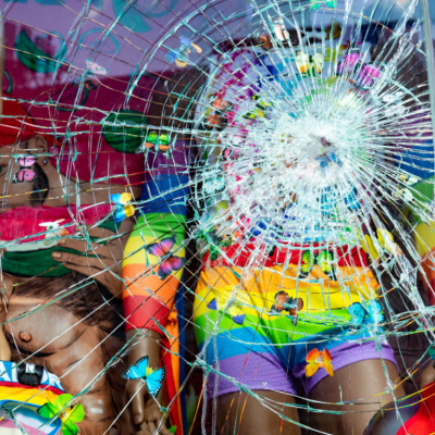 Broken window on LGBTQ fashion boutique storefront in New York City from vandalism.