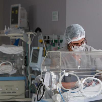 Medical professional tends to baby in NICU.