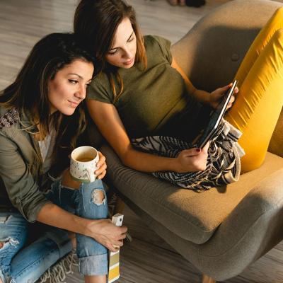 A lesbian couple are cozily engaging about apartment arrangements.