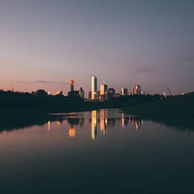 Dusky photo of Dallas skyline at night.