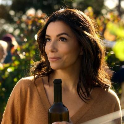 Eva Longoria holds a bottle of wine in the 2024 Apple TV+ series 'Land of Women.'