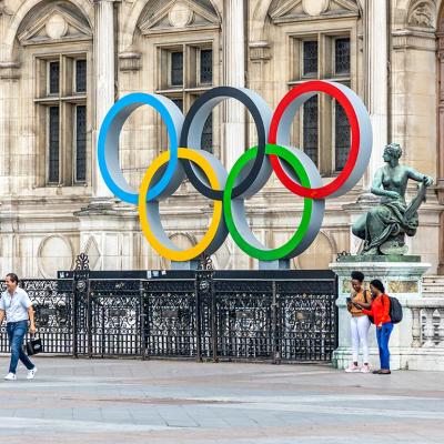 Tourists walking in the Hotel de Ville square with the Paris 2024 Olympic rings in front of the city hall in Paris, France.