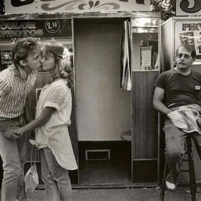 A young couple in front of a photo booth at the Alameda County Fair, Pleasanton, California, 1986.