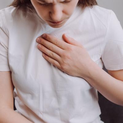 Person sitting on sofa having difficulty breathing.