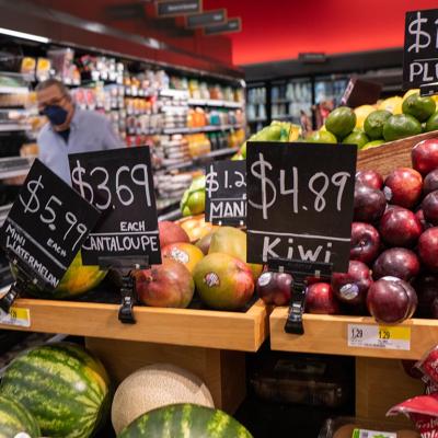 Grocery store prices in a New York store show apples and melons at high prices.