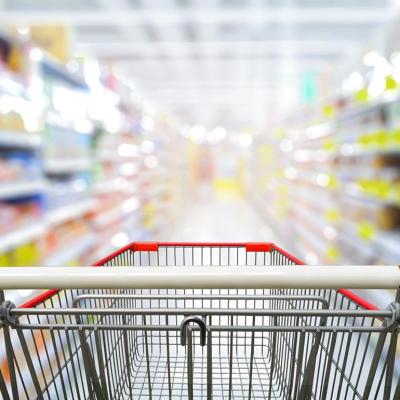 Shopping cart focusing at the center of a grocery aisle.
