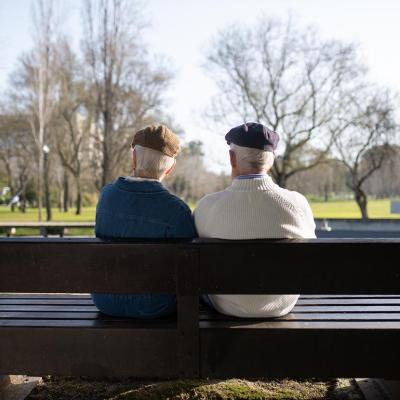 An old couple sittong on a bench park.