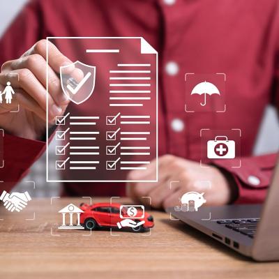 Graphic design checklist and icons representing risks overlaid on image of person sitting at a desk; concept of insurance.