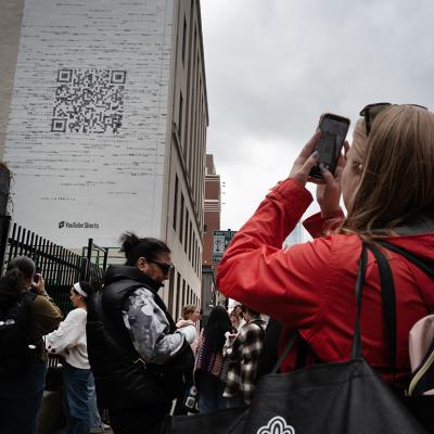 Taylor Swift fans gather outside a building where a mural featuring a large QR code was being painted to promote Swift's latest album, "The Tortured Poets Department," on April 17, 2024 in Chicago, Illinois.