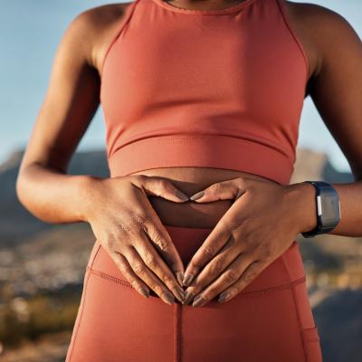 Person in athleisure wear putting hands on stomach.