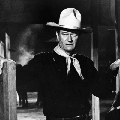 American actor John Wayne (1907 - 1979) wears a Western outfit which includes a pistol in a holster and stands in a doorway in a still from the Cowboy film 'The Man Who Shot Liberty Valance' directed by John Ford, 1962.