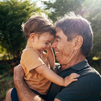 Grandparent spending time with grandchild in a park on a sunny day.