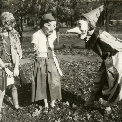 Three girls amuse each other with their masked costumes as they prepare for Halloween festivities in the College Hill neighborhood of Cincinnati, Ohio, 1929.