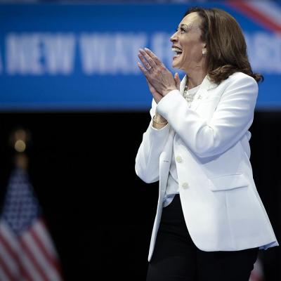 Democratic presidential nominee, U.S. Vice President Kamala Harris wearing white, greets the crowd as she arrives on stage at a campaign rally at the Enmarket Arena August 29, 2024 in Savannah, Georgia.