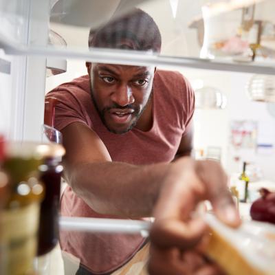 View from inside refrigerator as person reaches for groceries.