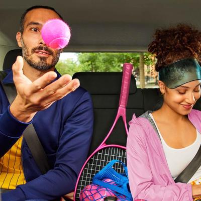 Two passengers wearing tennis outfits in the back of a rideshare vehicle.