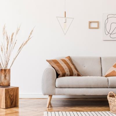 A living room with a modern gray couch and wood decor elements.