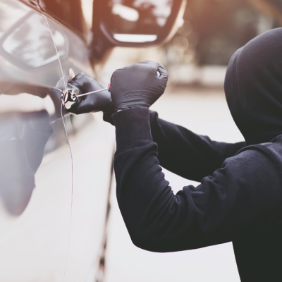 A car thief breaks a car window